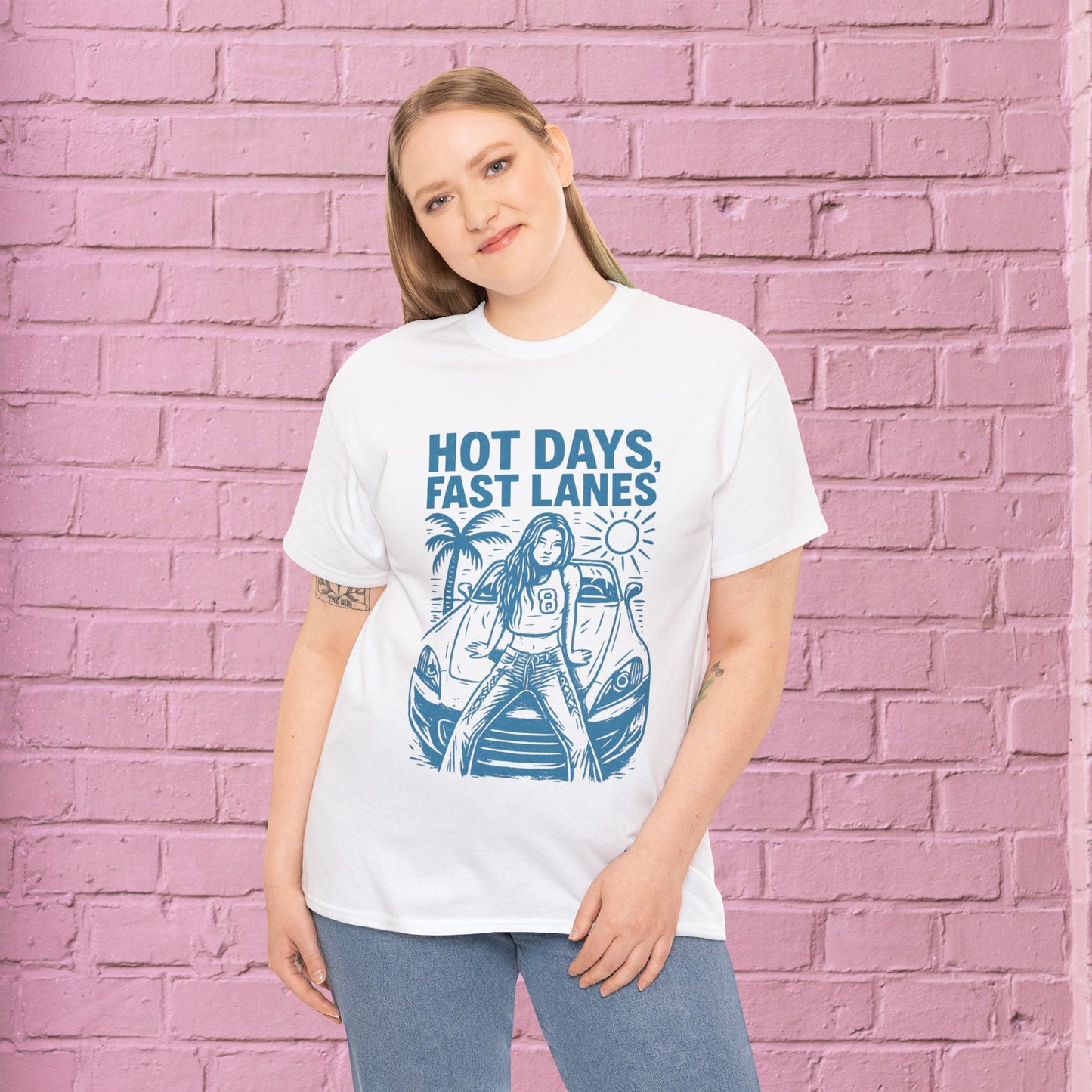 Person wearing a white t-shirt with blue graphic and text 'Hot Days, Fast Lanes' against a pink brick wall.