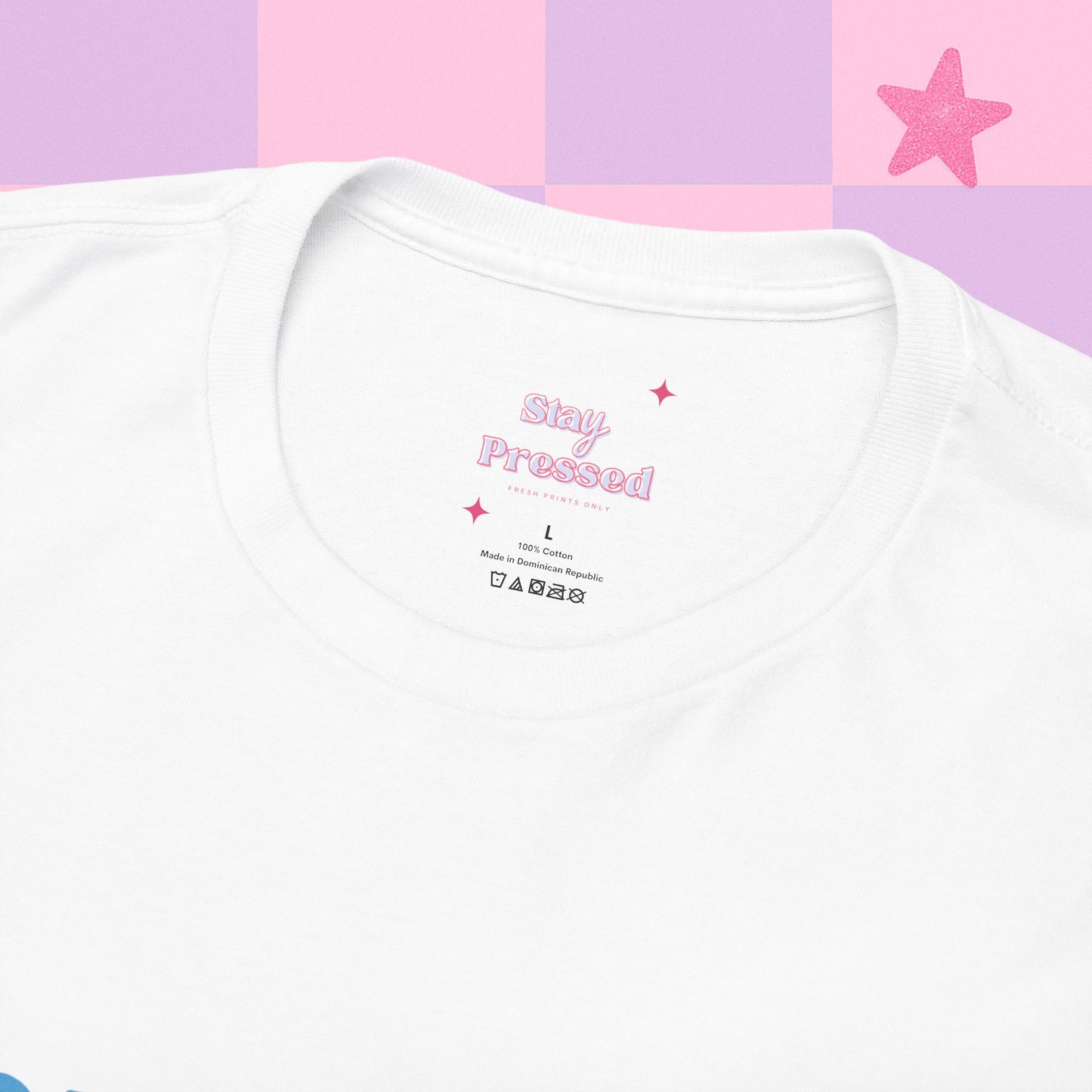 White t-shirt with 'Stay Pressed' text on a pink and purple checkered background. Close up shot of our logo and how the label will look.