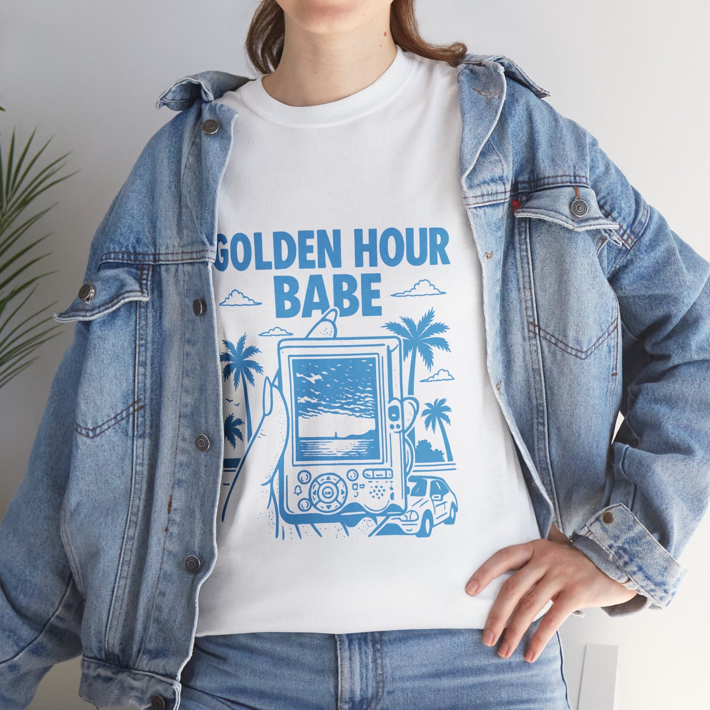 Person wearing a white t-shirt with 'Golden Hour Babe' design and a denim jacket.