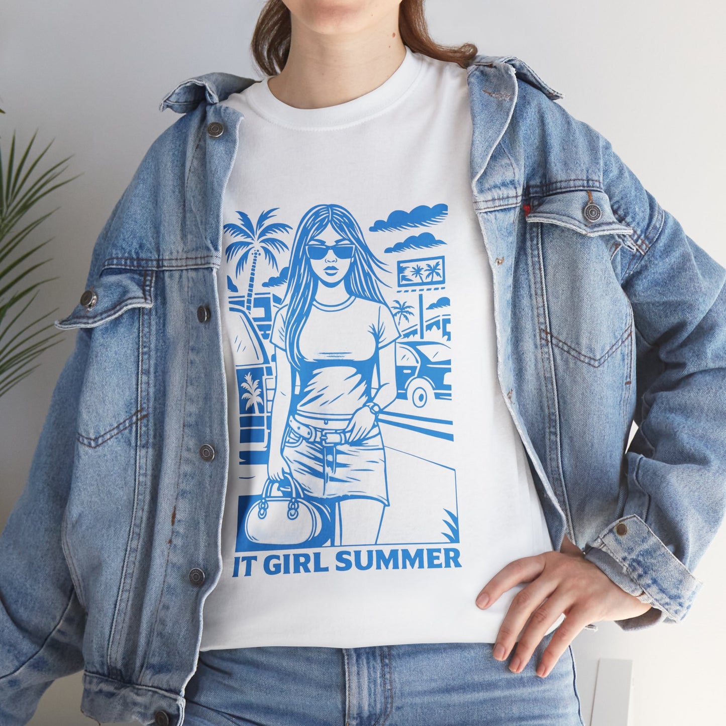 Person wearing a white t-shirt with blue graphic design and denim jacket.