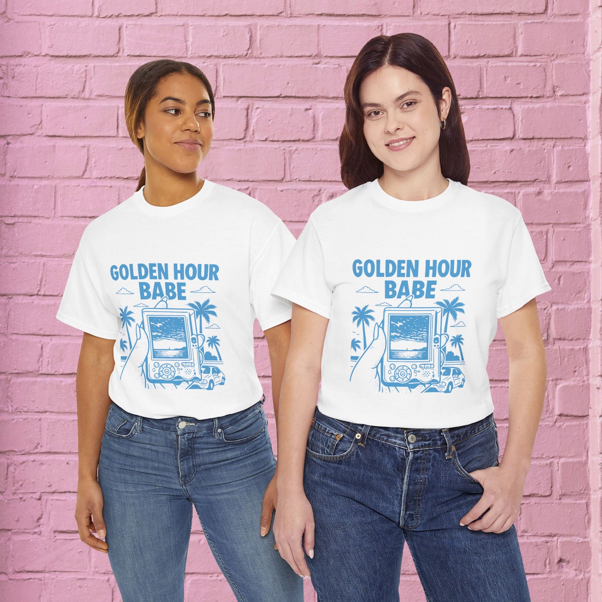 Two people wearing 'Golden Hour Babe' t-shirts against a pink brick wall.